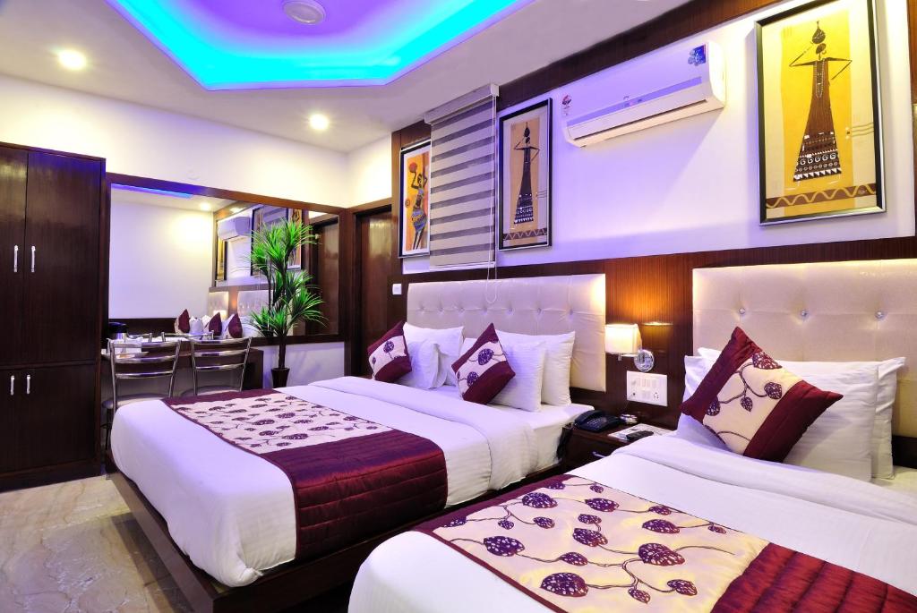 ein Hotelzimmer mit 2 Betten und einer Bar in der Unterkunft Hotel Nirmal Mahal - Paharganj - New Delhi in Neu-Delhi