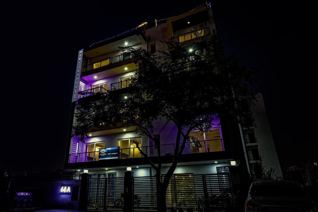 a tall building with purple lights on it at night at Townhouse Tipsyy Near Bestech Central Square Mall in Gurgaon