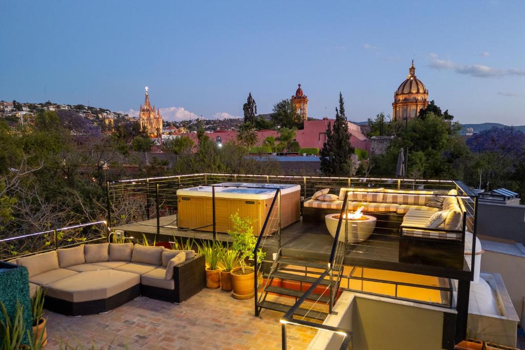 un toit-terrasse avec des canapés et un bain à remous dans l'établissement Casa Cielo, 4-Story Luxury Home with Rooftop Hot Tub & AC, à San Miguel de Allende