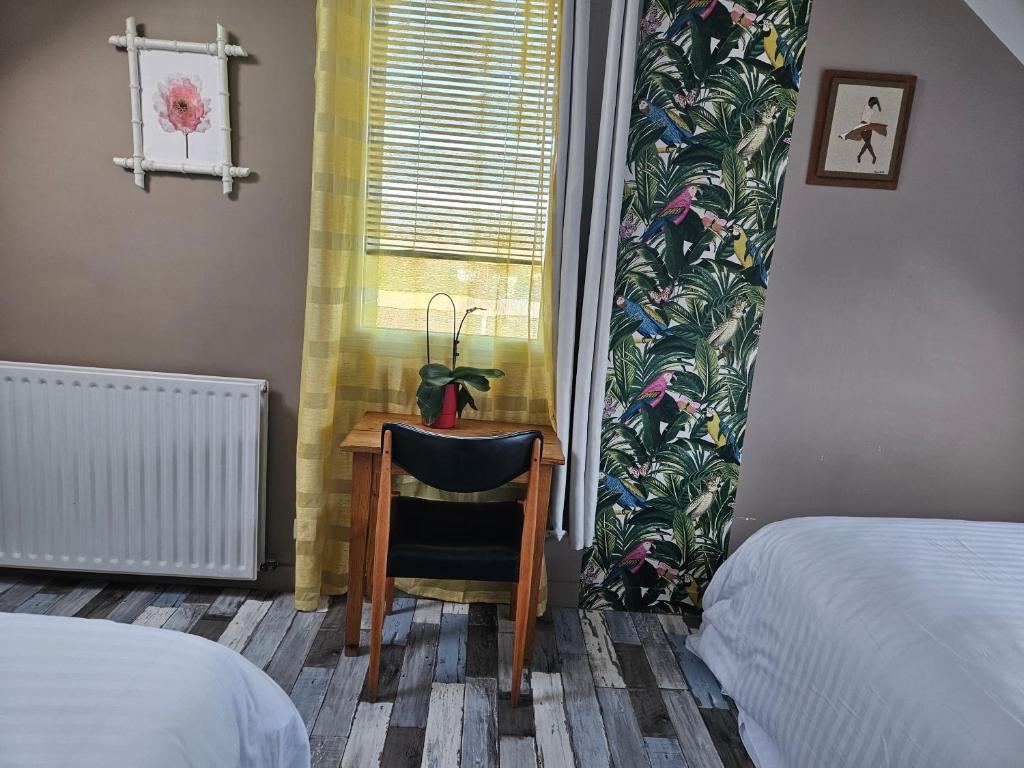 ein Schlafzimmer mit einem Schreibtisch mit einem Stuhl und einem Fenster in der Unterkunft Appartement du haut 1 in Cordemais