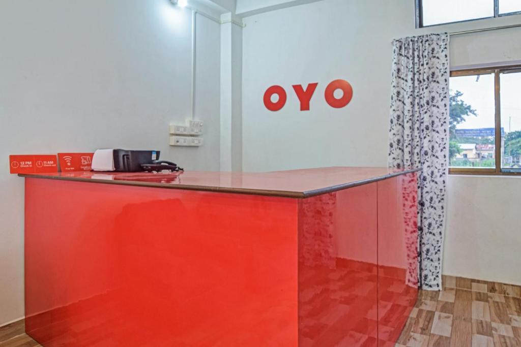 um escritório com um balcão vermelho e um sinal vo em SPOT ON Jp Guest House em Kāhārpāra