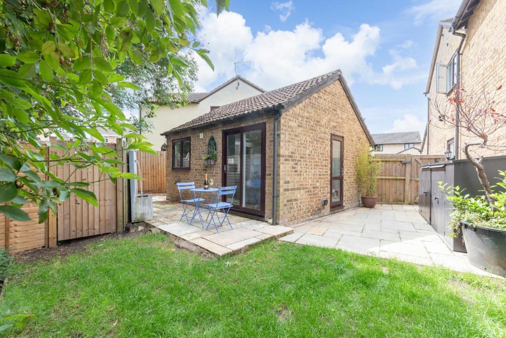 een patio met een tafel en stoelen in een tuin bij Peaceful & Beautifully Presented Detached Studio in Golden Valley