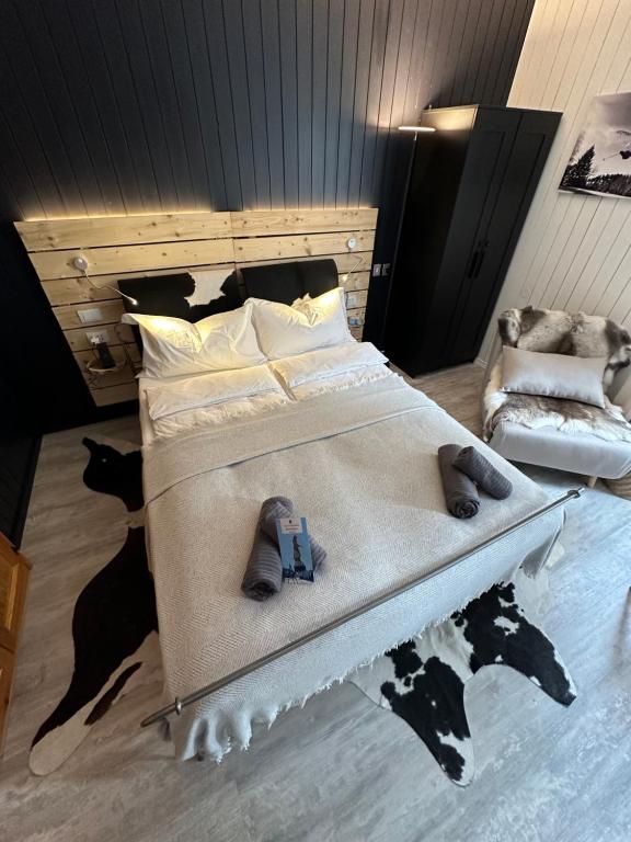 a bedroom with a large bed and a chair at Appartamento Kern-Sciare A Portata Di Mano- in Madesimo
