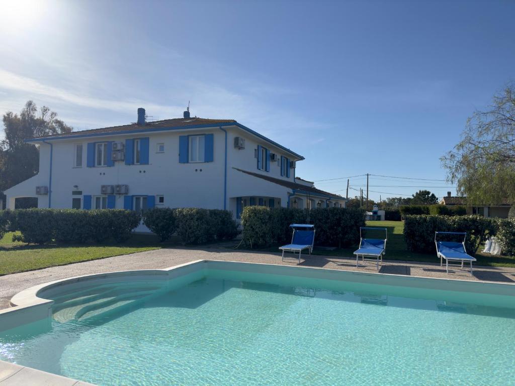 a house and a swimming pool in front of a house at Garden Hotel Alghero in Fertilia
