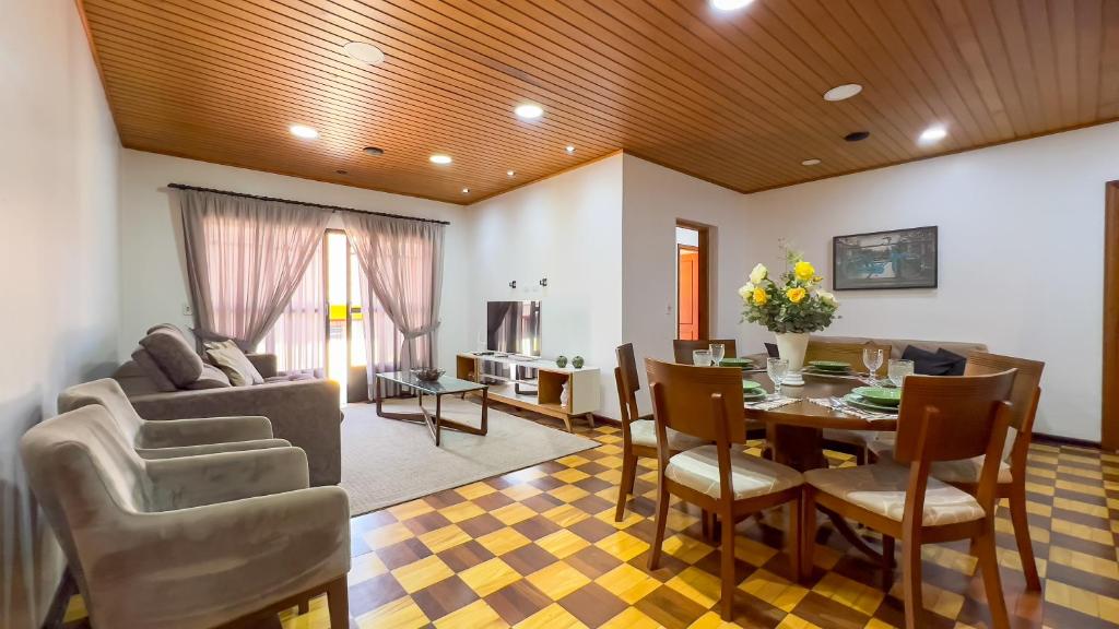 a dining room and living room with a table and chairs at Dúplex Jaguaribe in Campos do Jordão
