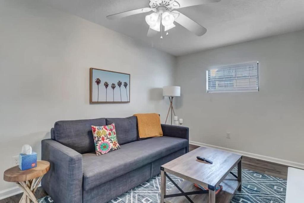 a living room with a couch and a ceiling fan at Amazing 1 BR apt - 1 block from Jax Beach! in Jacksonville Beach
