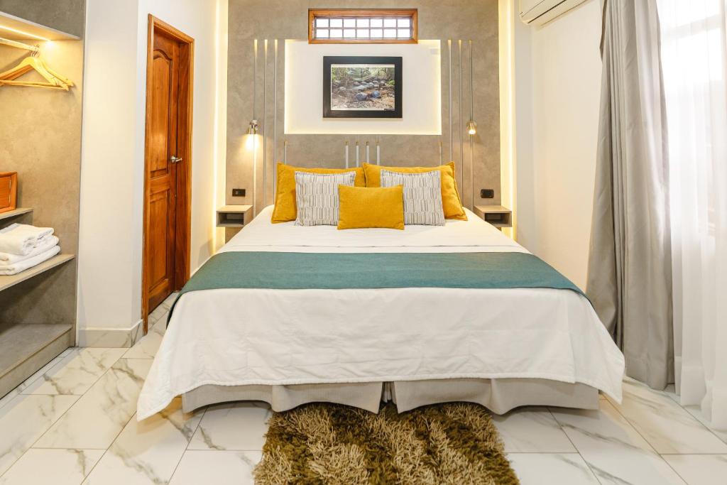 1 dormitorio con 1 cama grande con almohadas amarillas en Hotel Santa Fe, en Puerto Ayora