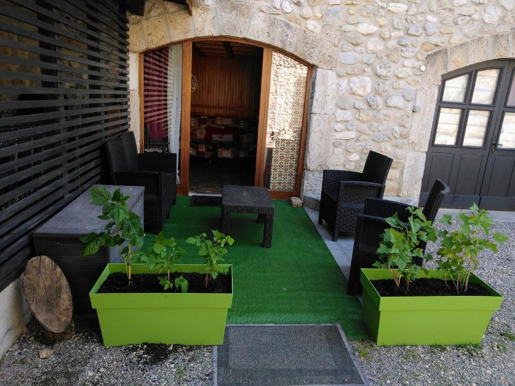 une terrasse avec des chaises noires et des plantes vertes dans l'établissement Gîte des papillons du vercors, à Bouvante-Haut