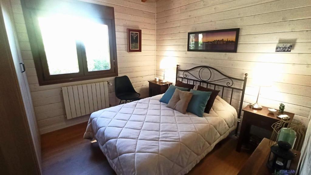 a bedroom with a bed with a white comforter at Habitación simple con baño in Guadarrama