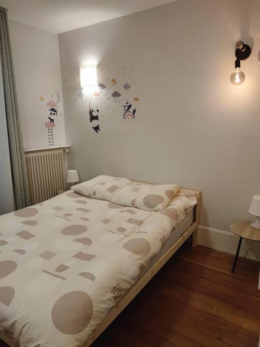 a bedroom with a bed with polka dots on the wall at Magnifique appartement de charme au cœur de Paris in Paris