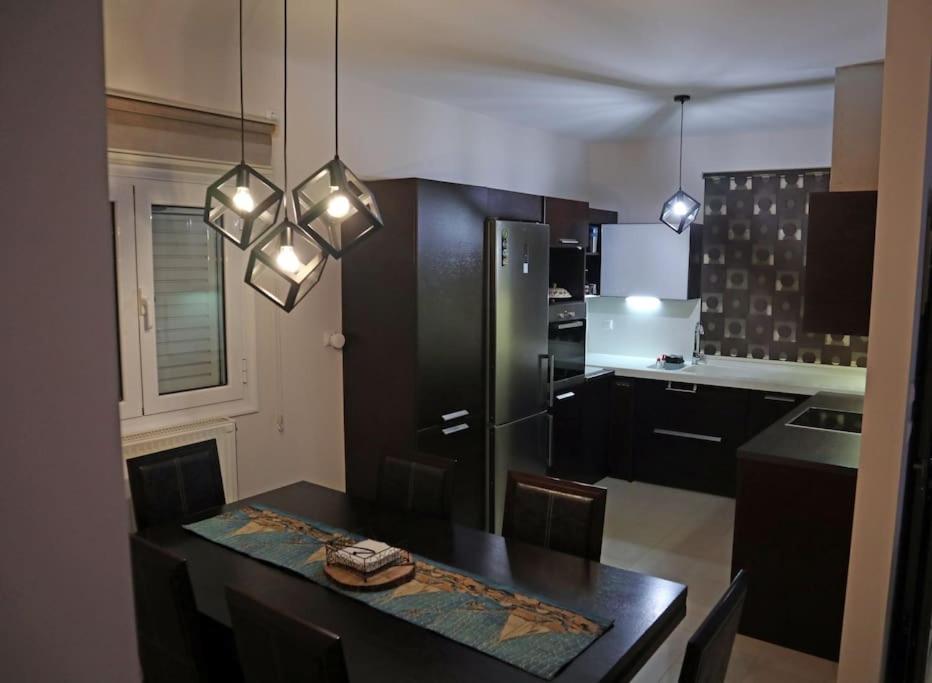 uma cozinha com uma mesa preta e um frigorífico em Cosy Beach House in Agios Vasilios, Patras em Áyios Vasílios