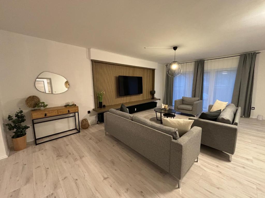 a living room with two couches and a television at 140qm - 4 Zimmer- Parkplatz - Autobahn - blauer See - MalliBase Apartments in Garbsen