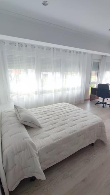 um quarto branco com uma cama grande e uma janela em Apartamento en Inferniño Ferrol em Ferrol