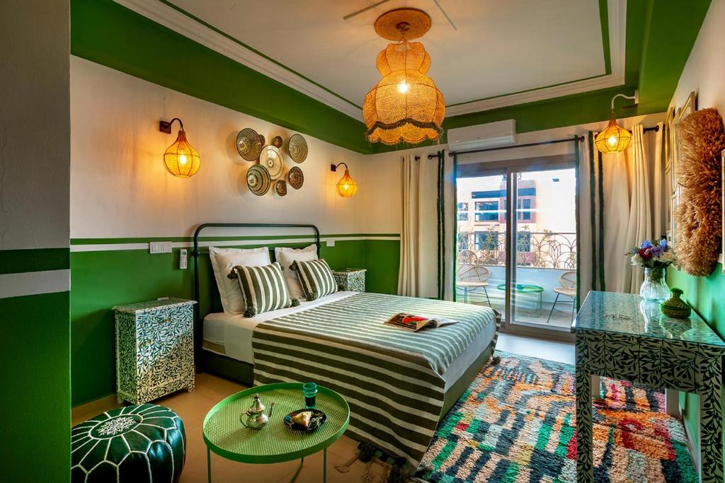 a bedroom with a bed and a table and a window at LES TANNEURS PENTHOUSE MARRAKECH in Marrakesh