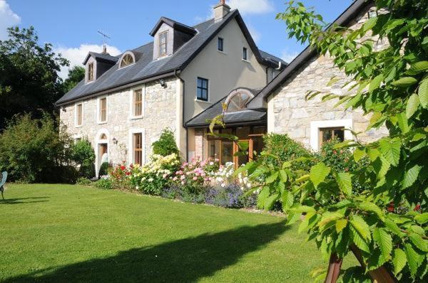 una gran casa de piedra con un patio verde en Grove House Rooms, en Cork