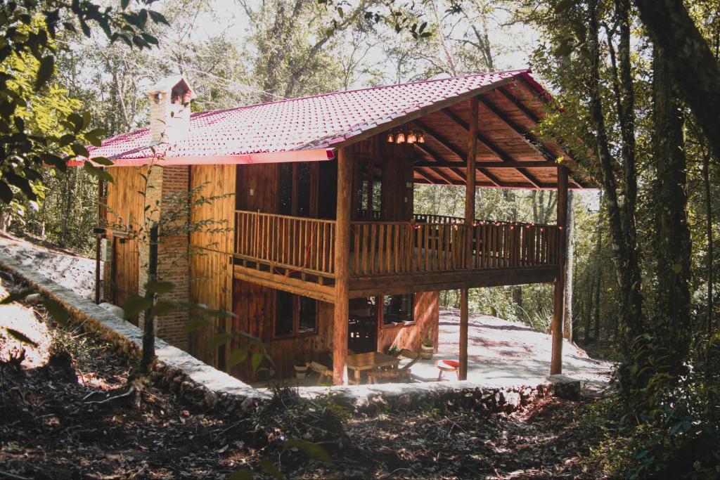 a tree house in the woods with a roof at Cabañas Los Encinos in Acaxochitlán
