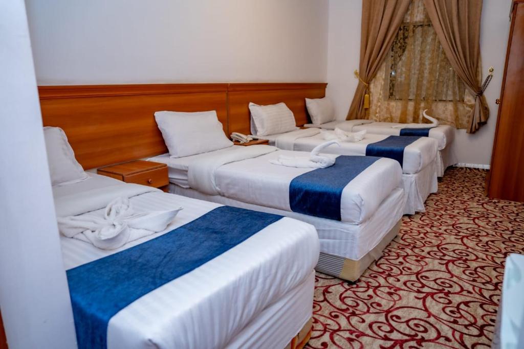 - une chambre d'hôtel avec 3 lits dans l'établissement فندق ليمة الفضية - Leema Al Fadya Hotel, à La Mecque