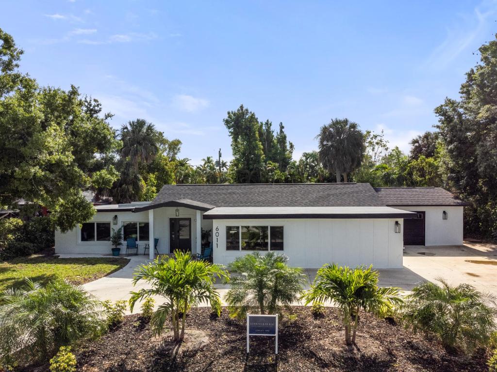 une maison avec des palmiers devant elle dans l'établissement Tropical Haven in Ft. Myers, à Fort Myers