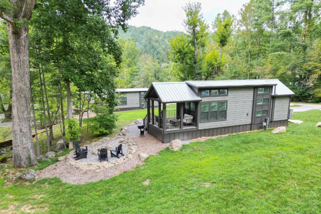 a tiny house in the middle of a yard at Farmhouse Tiny home with fishing Pond - Oak Cabin in Gatlinburg