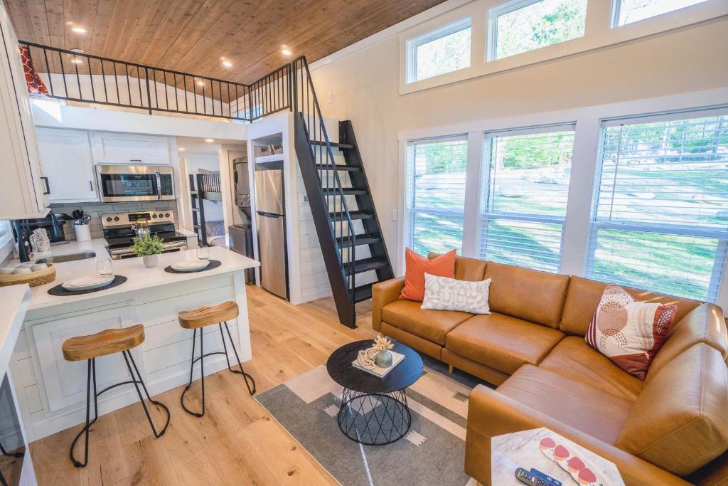 ein Wohnzimmer mit Couch und Küche in der Unterkunft Farmhouse Tiny home with fishing Pond - Oak Cabin in Gatlinburg