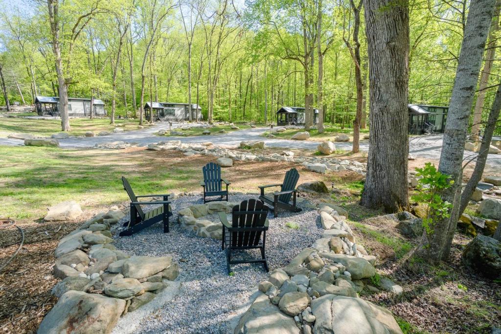 a group of three chairs sitting in a park at Farmhouse Tiny home with fishing Pond - Oak Cabin in Gatlinburg