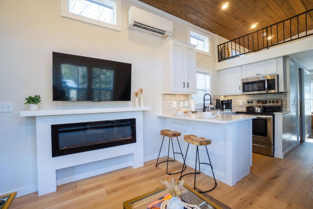 eine Küche mit einem Kamin und einem TV an der Wand in der Unterkunft Farmhouse Tiny home with fishing Pond - Oak Cabin in Gatlinburg