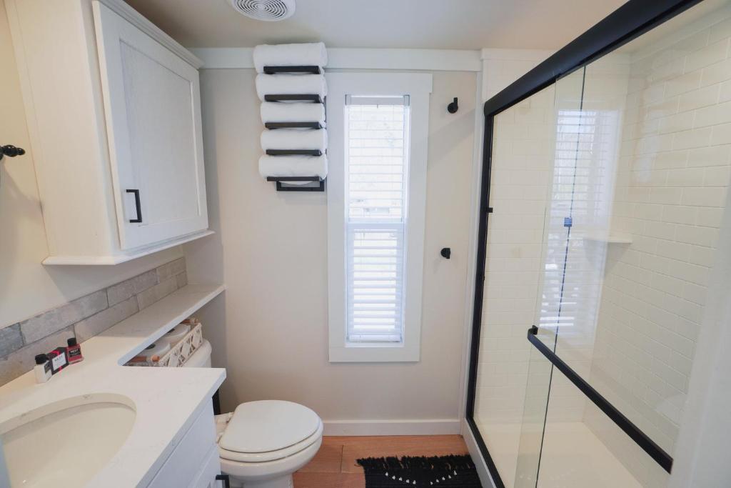 a bathroom with a toilet and a sink and a shower at Farmhouse Tiny home with fishing Pond - Oak Cabin in Gatlinburg