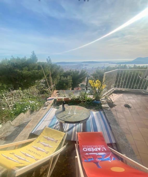un patio avec deux chaises et une table sur un balcon dans l'établissement Maison d'artistes avec vue panoramique sur la baie, à Toulon