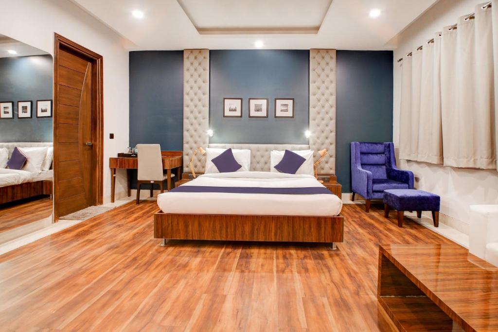 a bedroom with a bed and two blue chairs at SilverKey M&m Residency in New Delhi