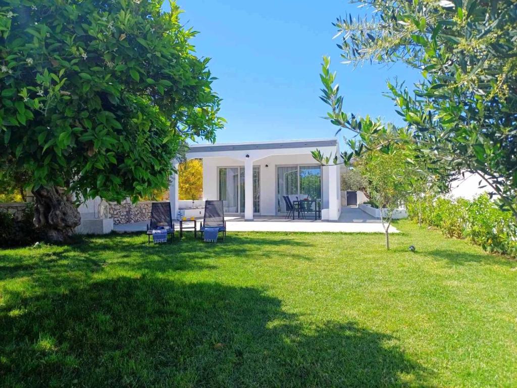 a yard with chairs and a house at Rhodes Soul luxury suites in Afantou