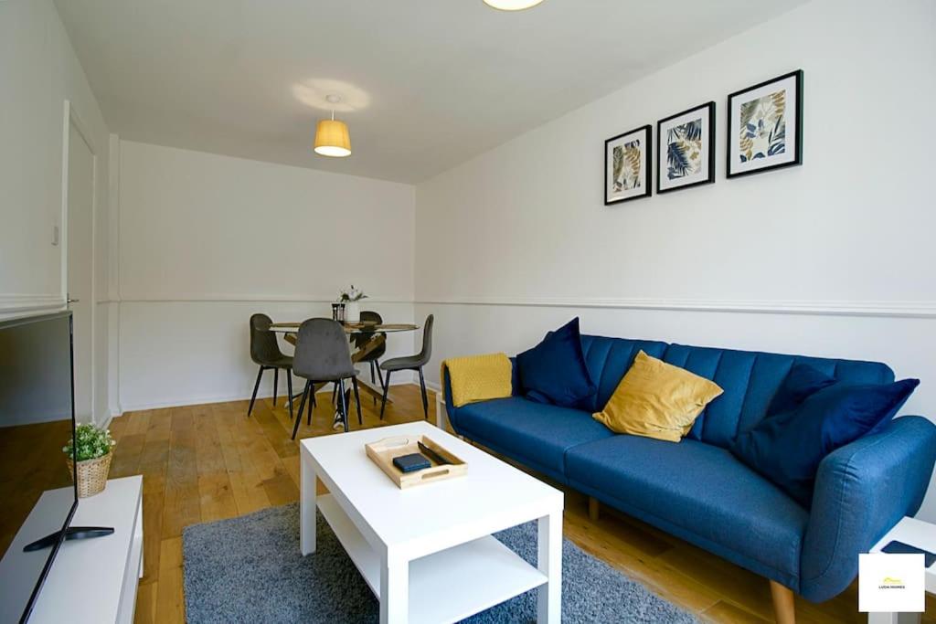 ein Wohnzimmer mit einem blauen Sofa und einem Tisch in der Unterkunft Beautiful City Centre Aprt/Sleeps 8/W Parking in Southampton