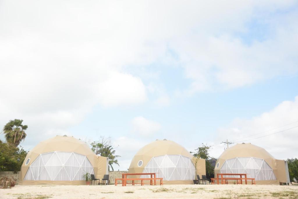 Deux tentes en forme de dôme avec tables de pique-nique dans le désert dans l'établissement Hidden Island Glamping Isla Mujeres, à Isla Mujeres