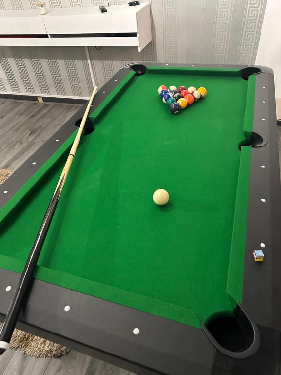 a pool table with a cue and balls on it at Versace Suite in Blackpool