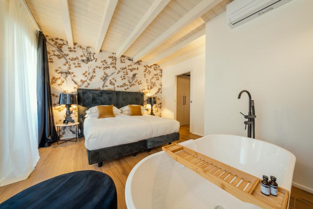 Schlafzimmer mit einem Bett und einer Badewanne in der Unterkunft Il Vicolo Suite Apartments - Il Corso in Tignale