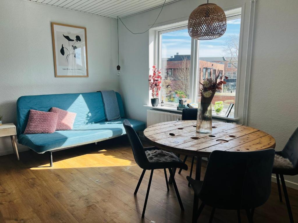 a living room with a blue couch and a table at The Old Hotel Silkeborg - 1TH in Silkeborg
