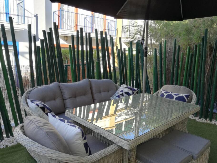 uma mesa de vidro e cadeiras com um guarda-sol em Casa Bambu, Paraiso na Terra em Praia Verde