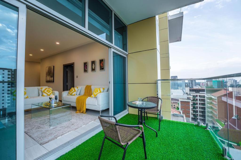 2Bedroom Skynest Luxury Apartment Westlands City Views في نيروبي: غرفة معيشة مع أريكة وطاولة وكراسي