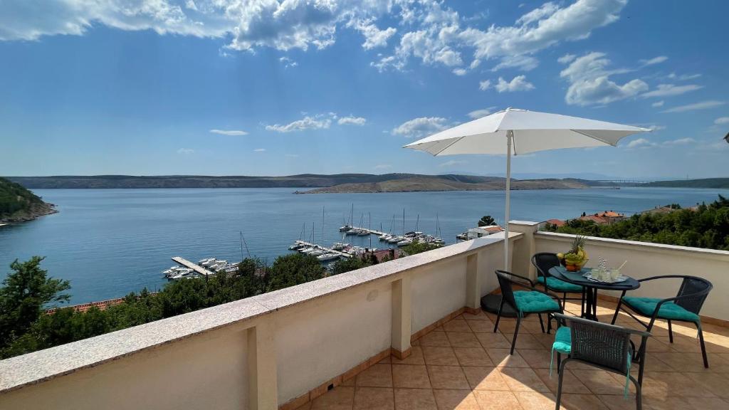 a balcony with a table and chairs and a view of the water at Apartment More in Jadranovo