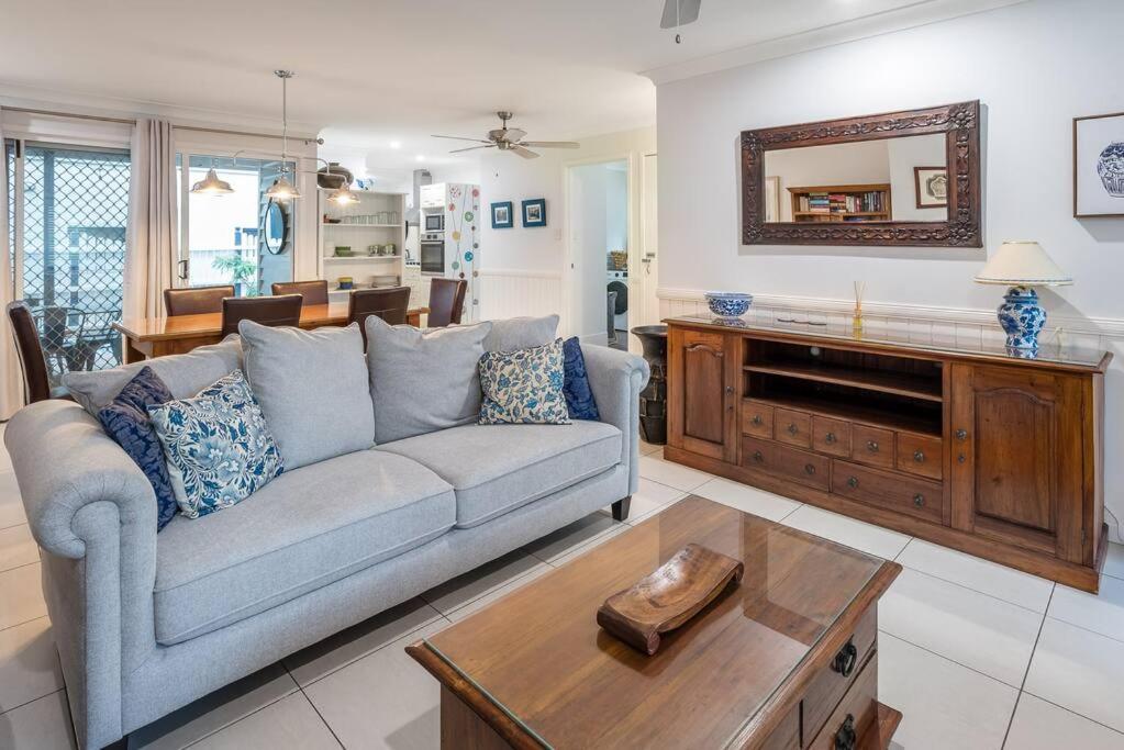 uma sala de estar com um sofá e uma mesa em BirdSong Yeronga - Inner City Village Sanctuary em Brisbane