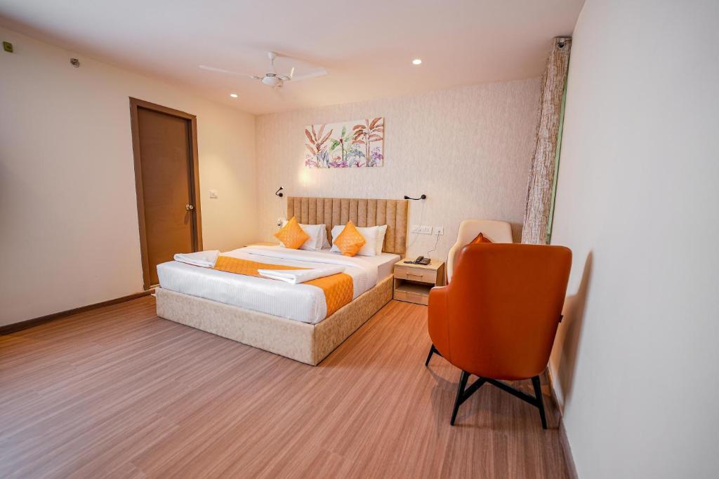 1 dormitorio con 1 cama y 1 silla en Hotel Golden Tower At Delhi Airport, en Nueva Delhi