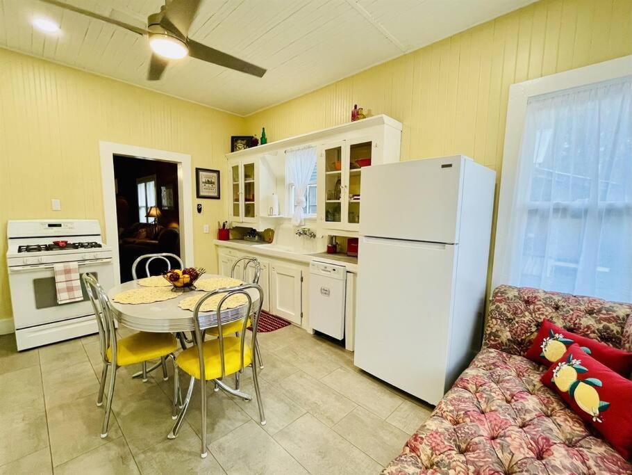 uma cozinha com uma mesa e um frigorífico branco em Spacious Waterfront Cottage + 2.5 Acres on the Bay em Lafayette