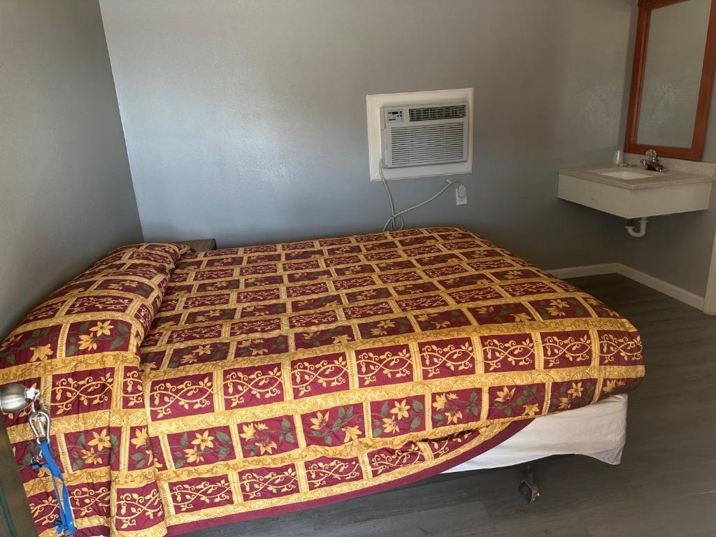 Una cama en una habitación con un edredón. en super inn en Newport