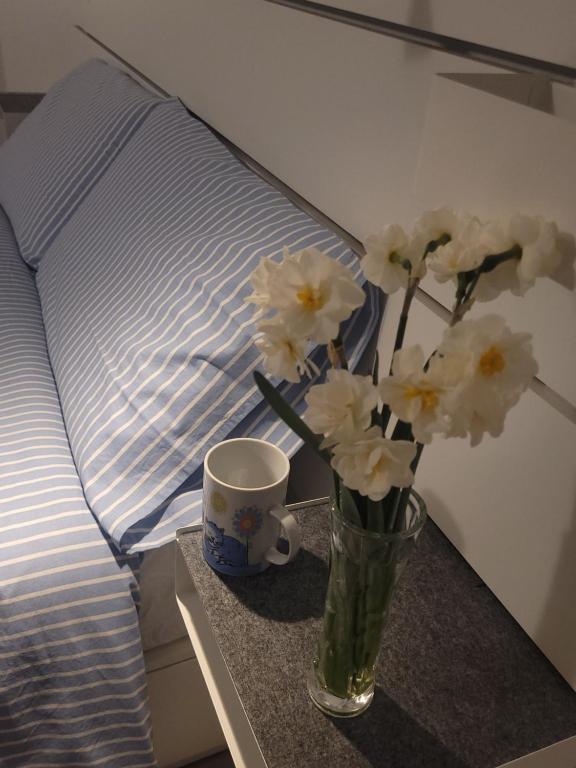 un vaso di fiori su un tavolo accanto a un letto di La casetta a Cuneo