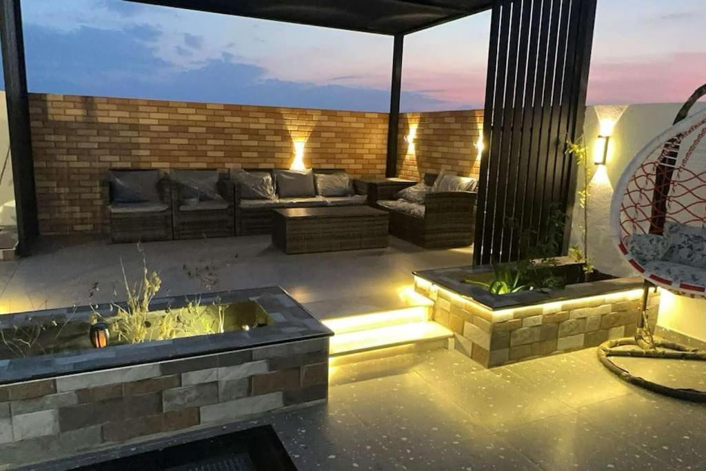 patio al aire libre con sofá y mesa en استراحه فندقيه فخمه نطاق المدينه بخصم ترويجي, en Billah