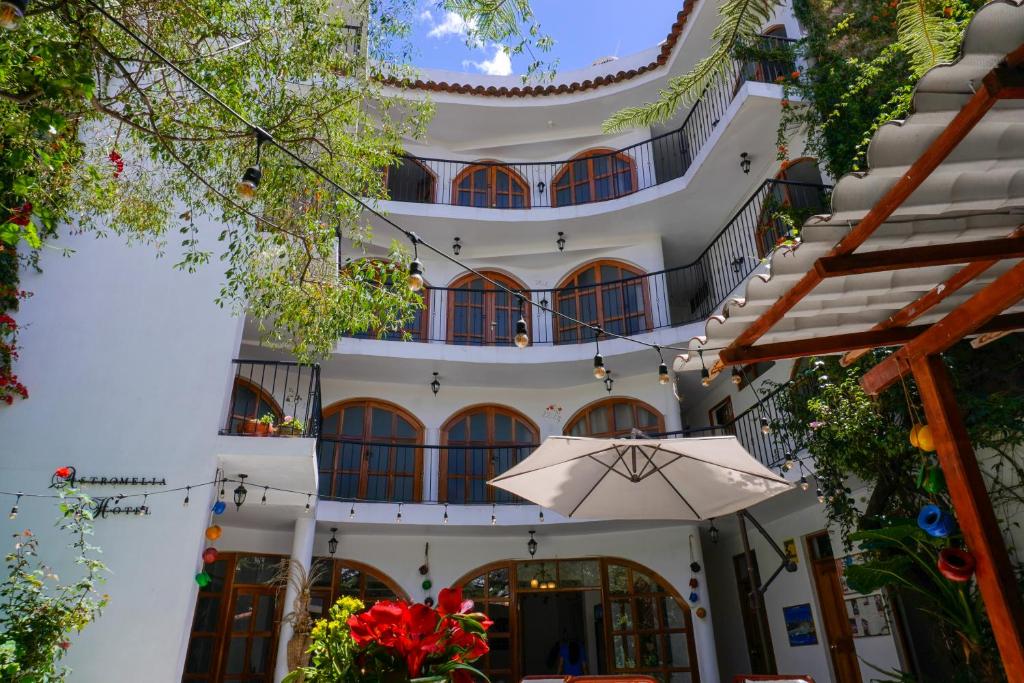 un edificio con un ombrello davanti di Astromelia Hotel ad Ayacucho