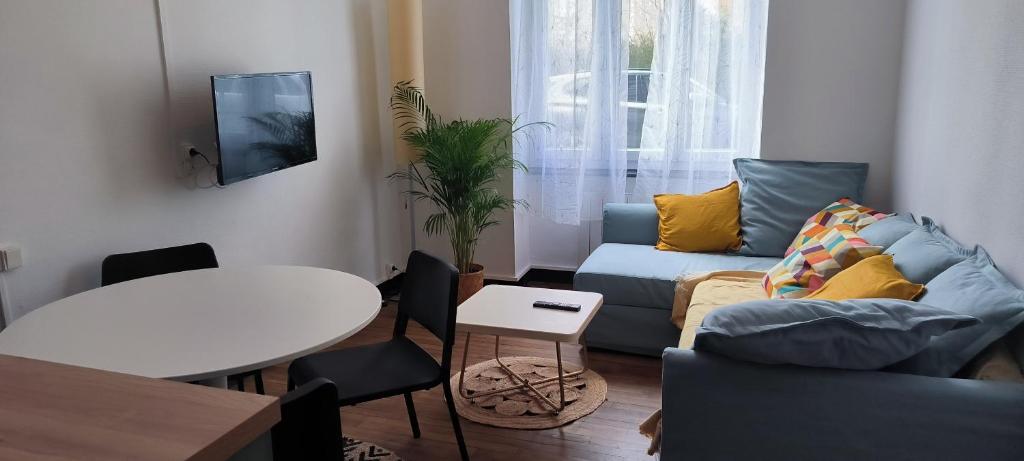 uma sala de estar com um sofá e uma mesa em cocooning centre Dinan em Dinan