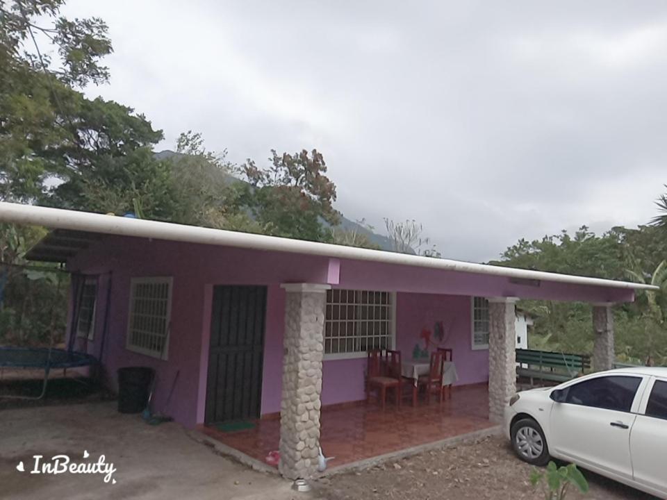 een roze huis met een auto ervoor geparkeerd bij Casa kadosh. in Antón