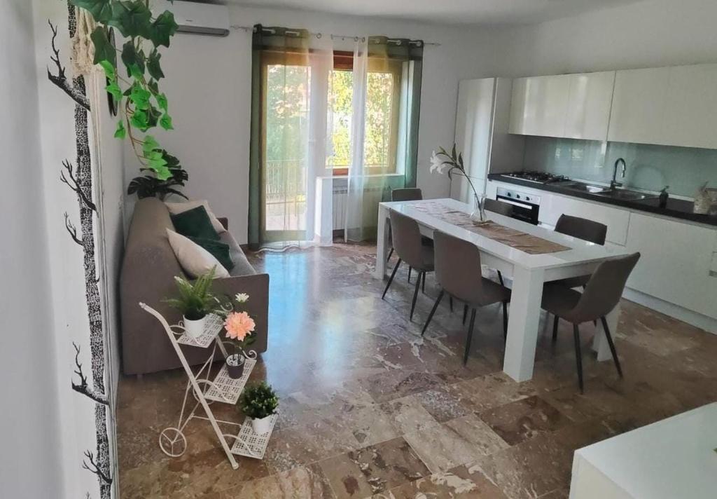 a kitchen and living room with a table and chairs at Roma amoR Vitinia in Vitinia