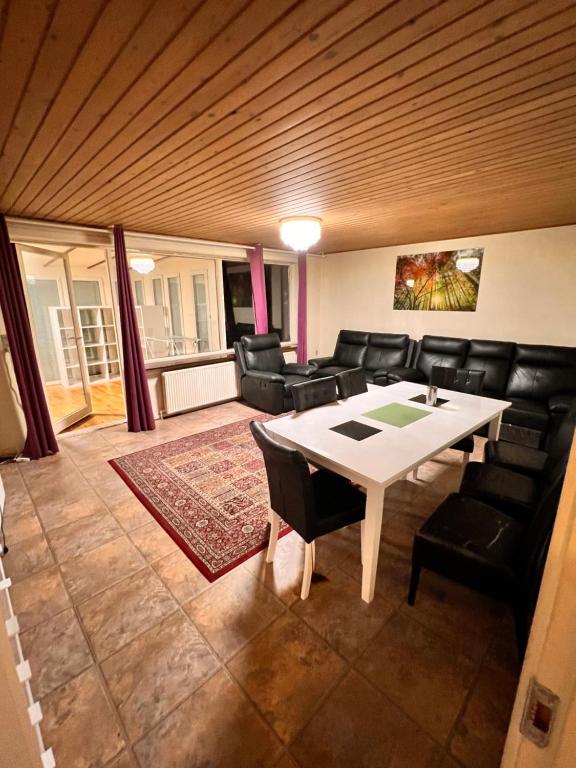 HBA Appartments Rodovre في Rødovre: غرفة معيشة مع طاولة بيضاء وكراسي سوداء