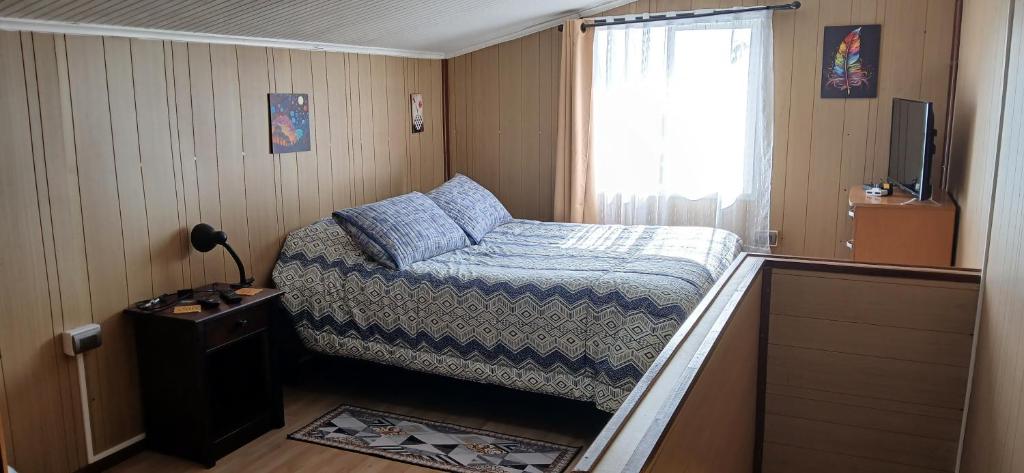 - une petite chambre avec un lit et une fenêtre dans l'établissement Cabañas Los Geranios, à Osorno
